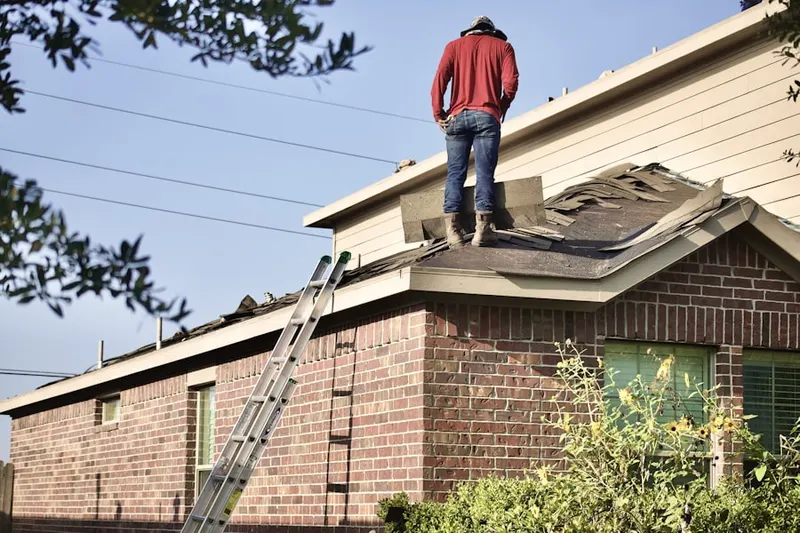 Professional roofer working on a residential roof in Dyer